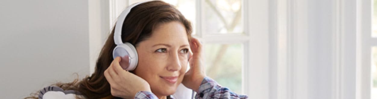 Woman listening to headphones at dialysis center.